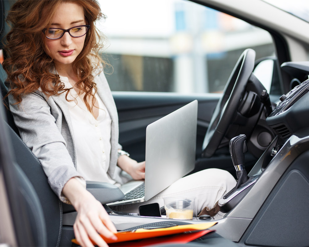 woman-in-a-car-with-laptop-and-paperwork-baton-opelousas-la
